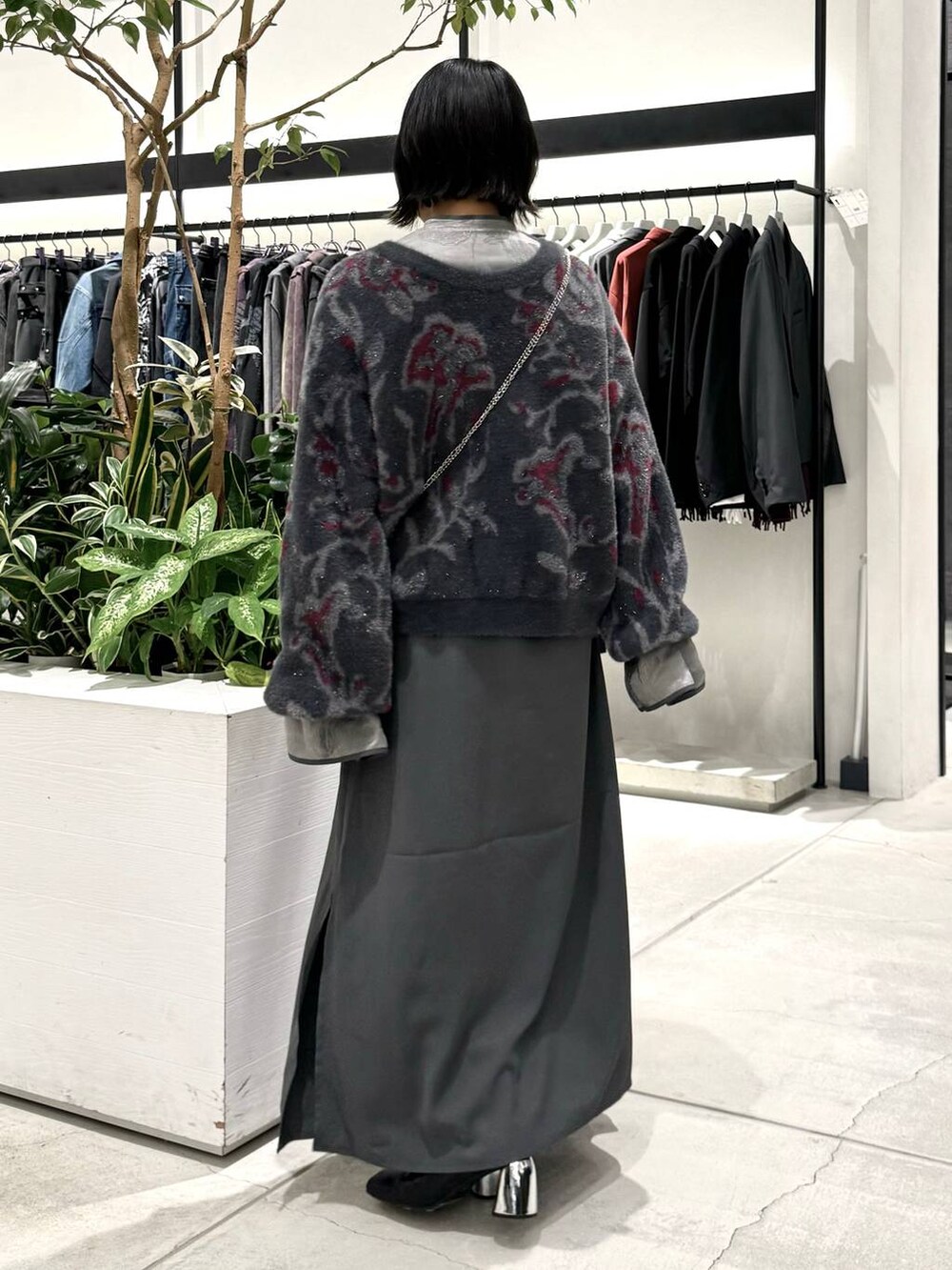 ブラック系のブーツ、ブラック系のカーディガン/ボレロ、グレー系のワンピースを着用したレディースの秋コーディネートの4枚目の写真