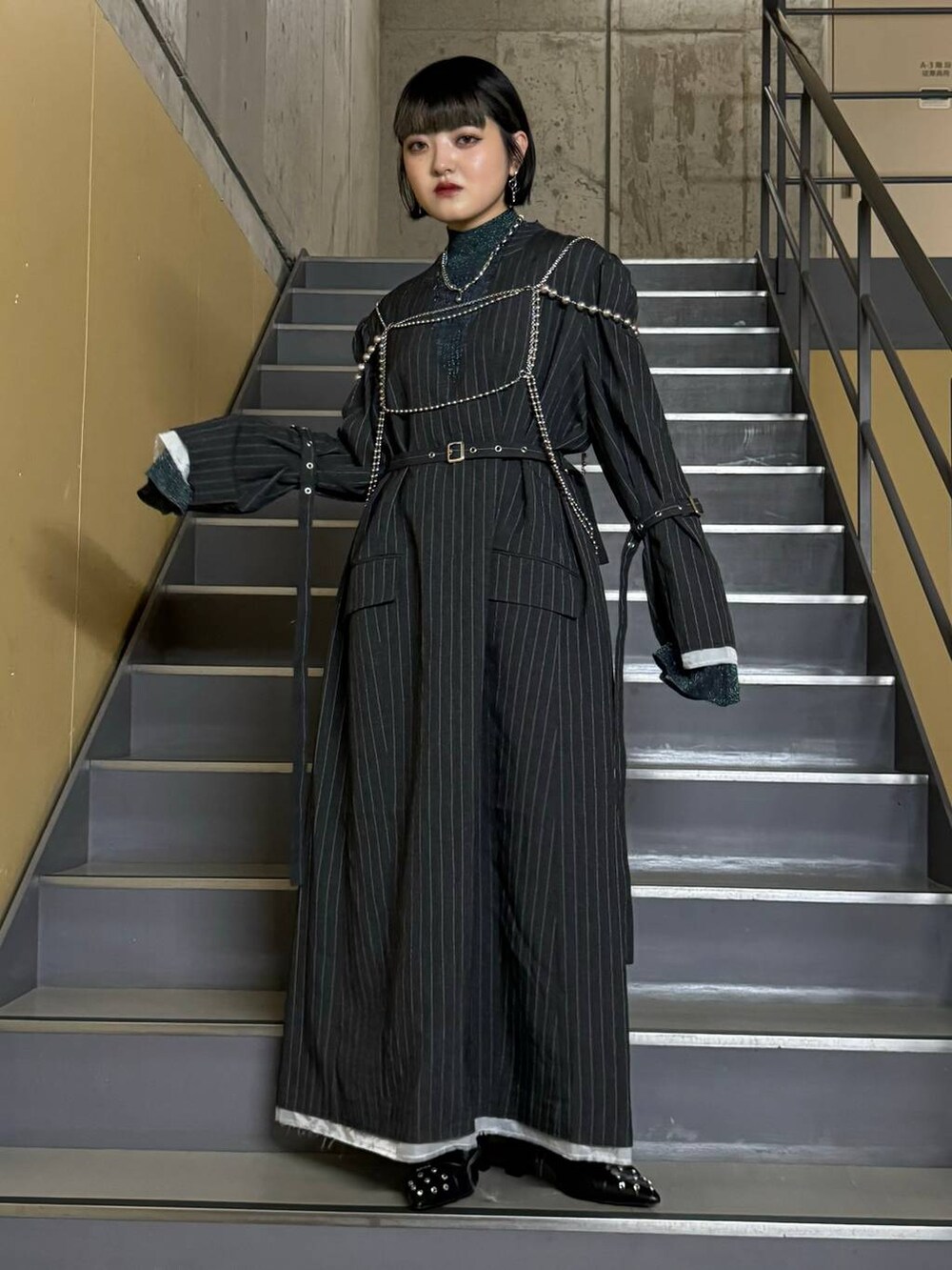 ブラック系のパンプス、ブルー系のニット/セーター、グレー系のワンピースを着用したレディースの秋コーディネートの4枚目の写真