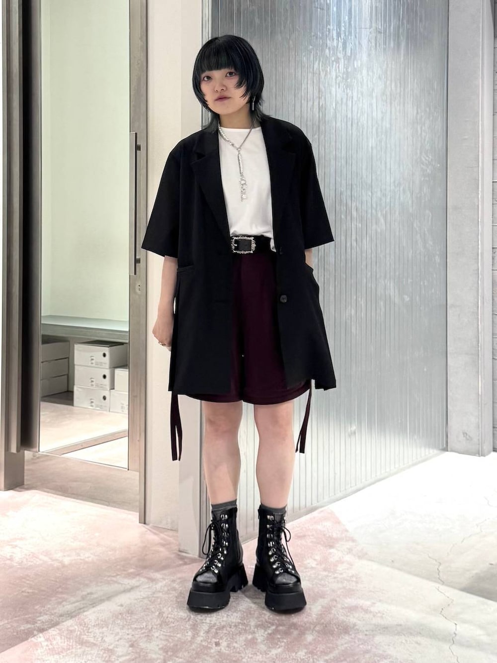 ブラック系のテーラードジャケット、レッド系のその他パンツ、シルバー系のタンクトップを着用したレディースの夏コーディネートの7枚目の写真