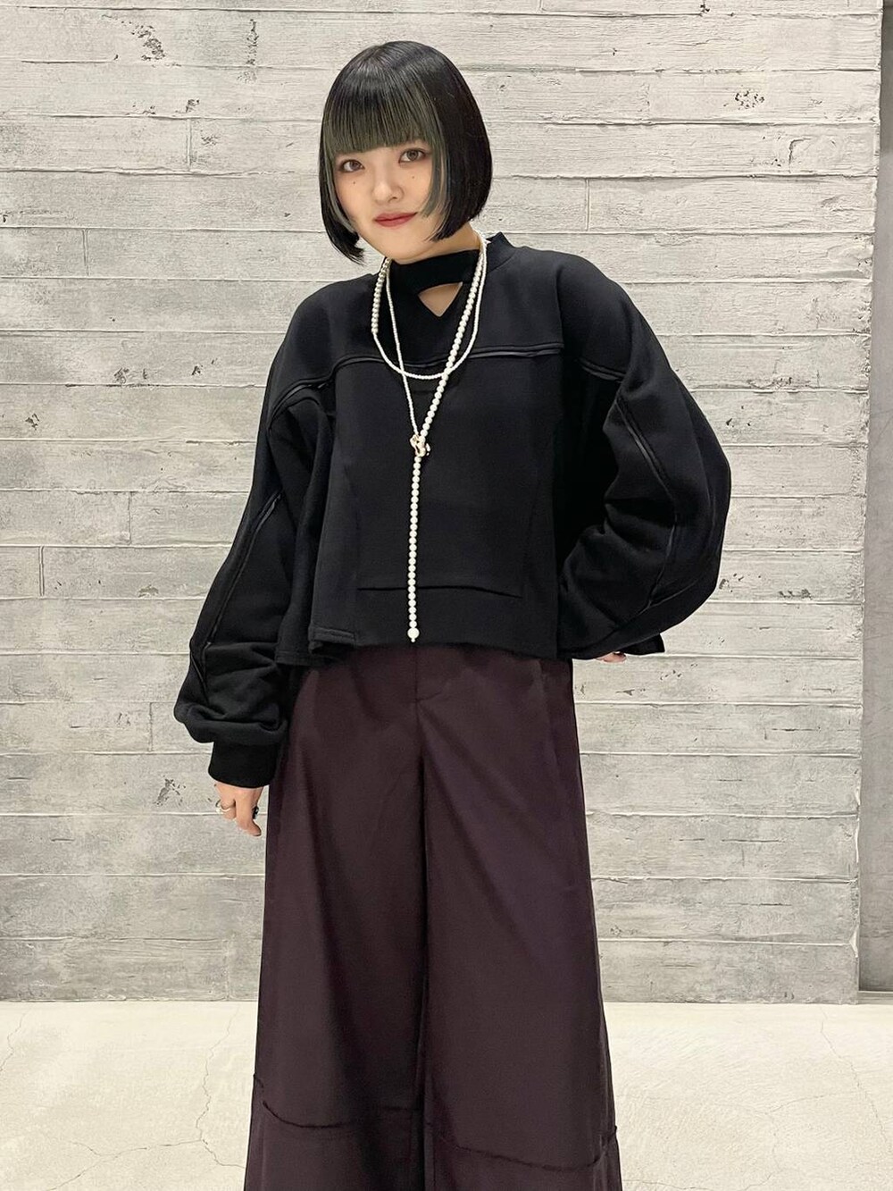 シルバー系のブーツ、ブラック系のスウェット、レッド系のその他パンツを着用したレディースの秋コーディネートの2枚目の写真