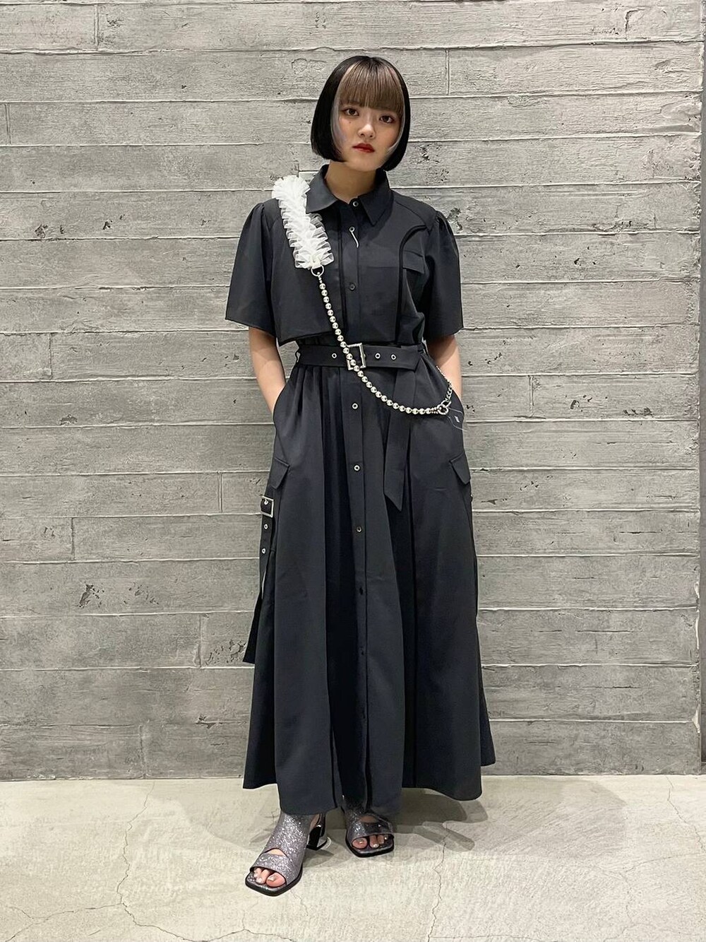 シルバー系のサンダル、グレー系のワンピース、ホワイト系のスマホグッズを着用したレディースの夏コーディネートの5枚目の写真