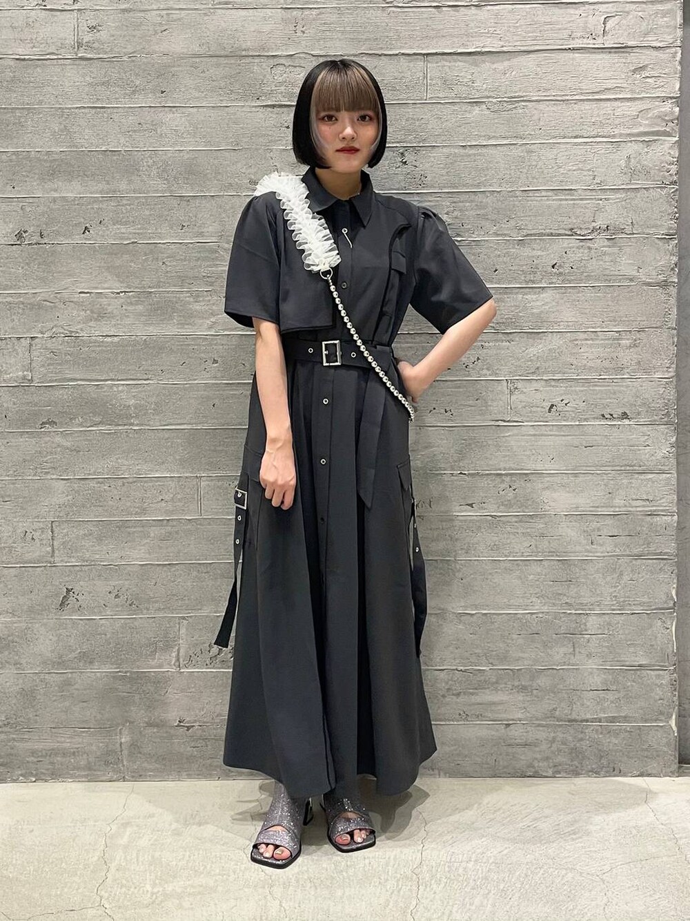 シルバー系のサンダル、グレー系のワンピース、ホワイト系のスマホグッズを着用したレディースの夏コーディネートの2枚目の写真