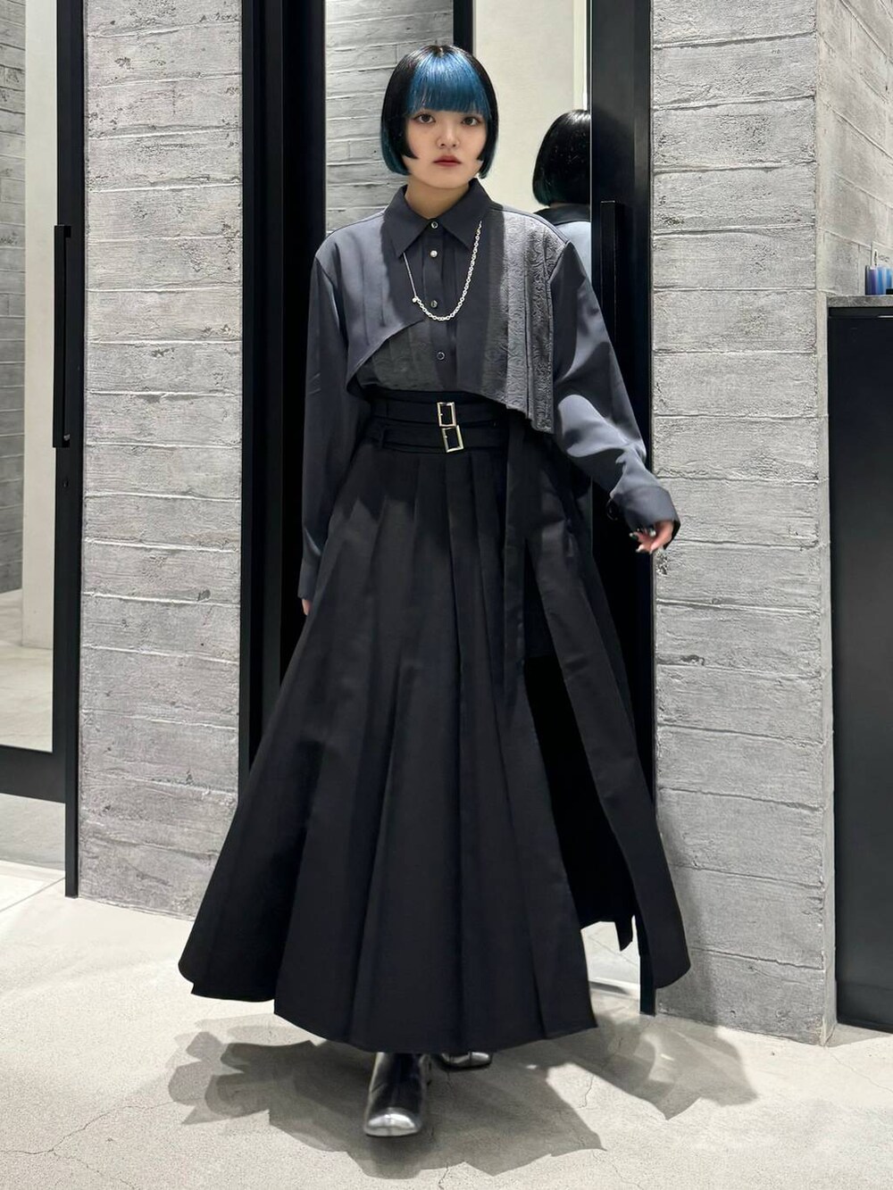 シルバー系のブーツ、グレー系のシャツ/ブラウス、ブラック系のスカートを着用したレディースの秋コーディネートの5枚目の写真