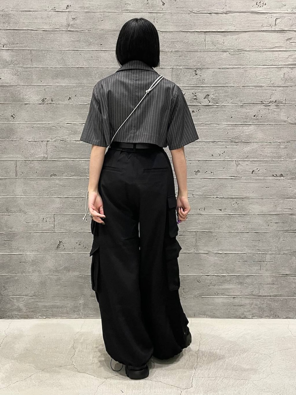 グレー系のタンクトップ、ブラック系のカーゴパンツ、グレー系のブルゾンを着用したレディースの夏コーディネートの4枚目の写真