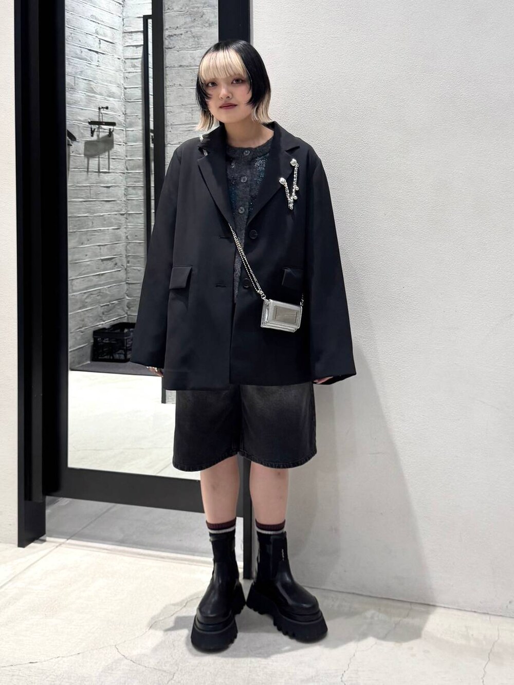 ブラック系のブーツ、グレー系のデニムパンツ、ブラック系のカーディガン/ボレロを着用したレディースの冬コーディネートの5枚目の写真