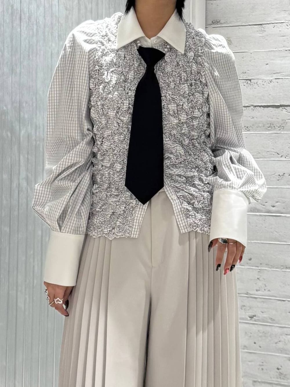 ブラック系のネクタイ、ブラック系のパンプス、ホワイト系のシャツ/ブラウスを着用したレディースの冬コーディネートの3枚目の写真