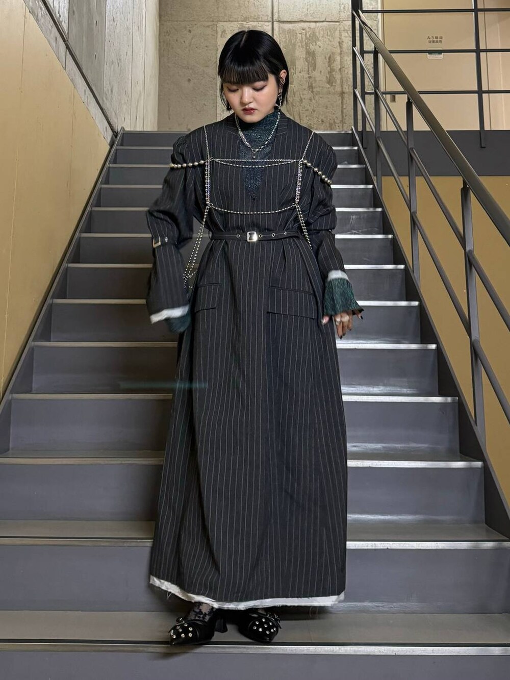 ブラック系のパンプス、ブルー系のニット/セーター、グレー系のワンピースを着用したレディースの秋コーディネートの3枚目の写真