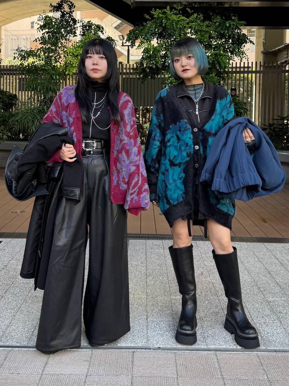 ブルー系のブルゾン、ブラック系のチェスターコート、レッド系のカーディガン/ボレロを着用したレディースの秋コーディネートの3枚目の写真
