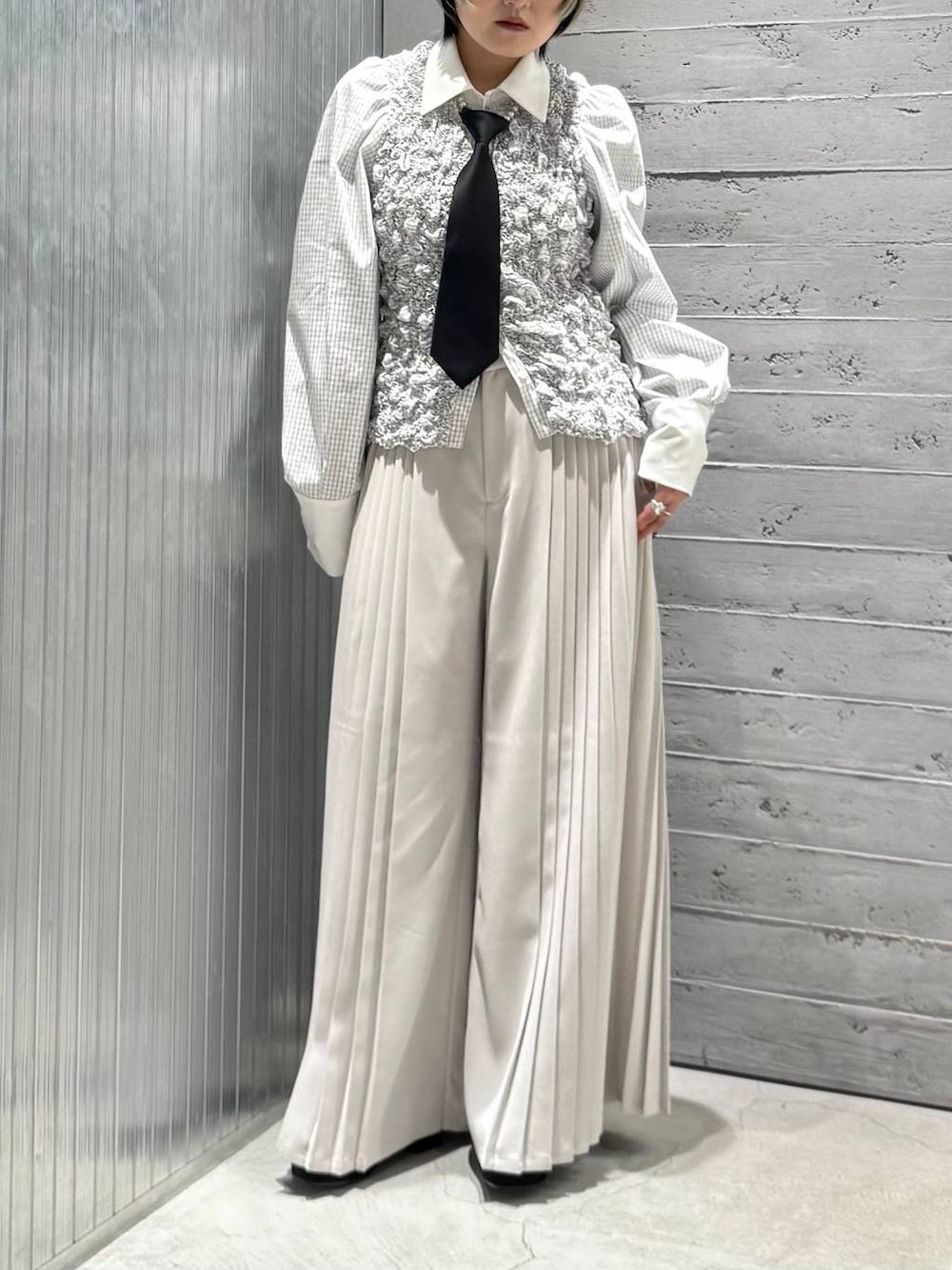 ブラック系のネクタイ、ブラック系のパンプス、ホワイト系のシャツ/ブラウスを着用したレディースの冬コーディネートの2枚目の写真