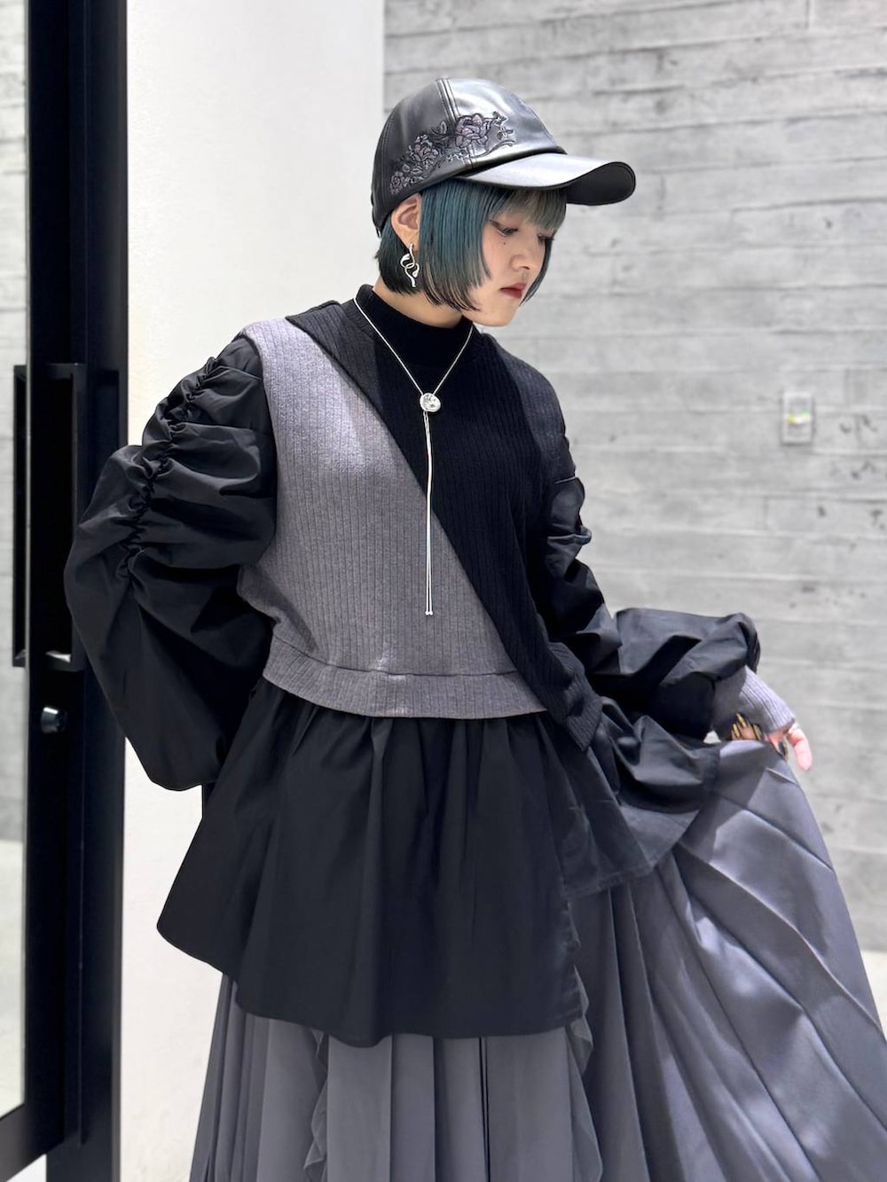 グレー系のスカート、グレー系のブーツ、ブラック系のシャツ/ブラウスを着用したレディースの秋コーディネートの8枚目の写真