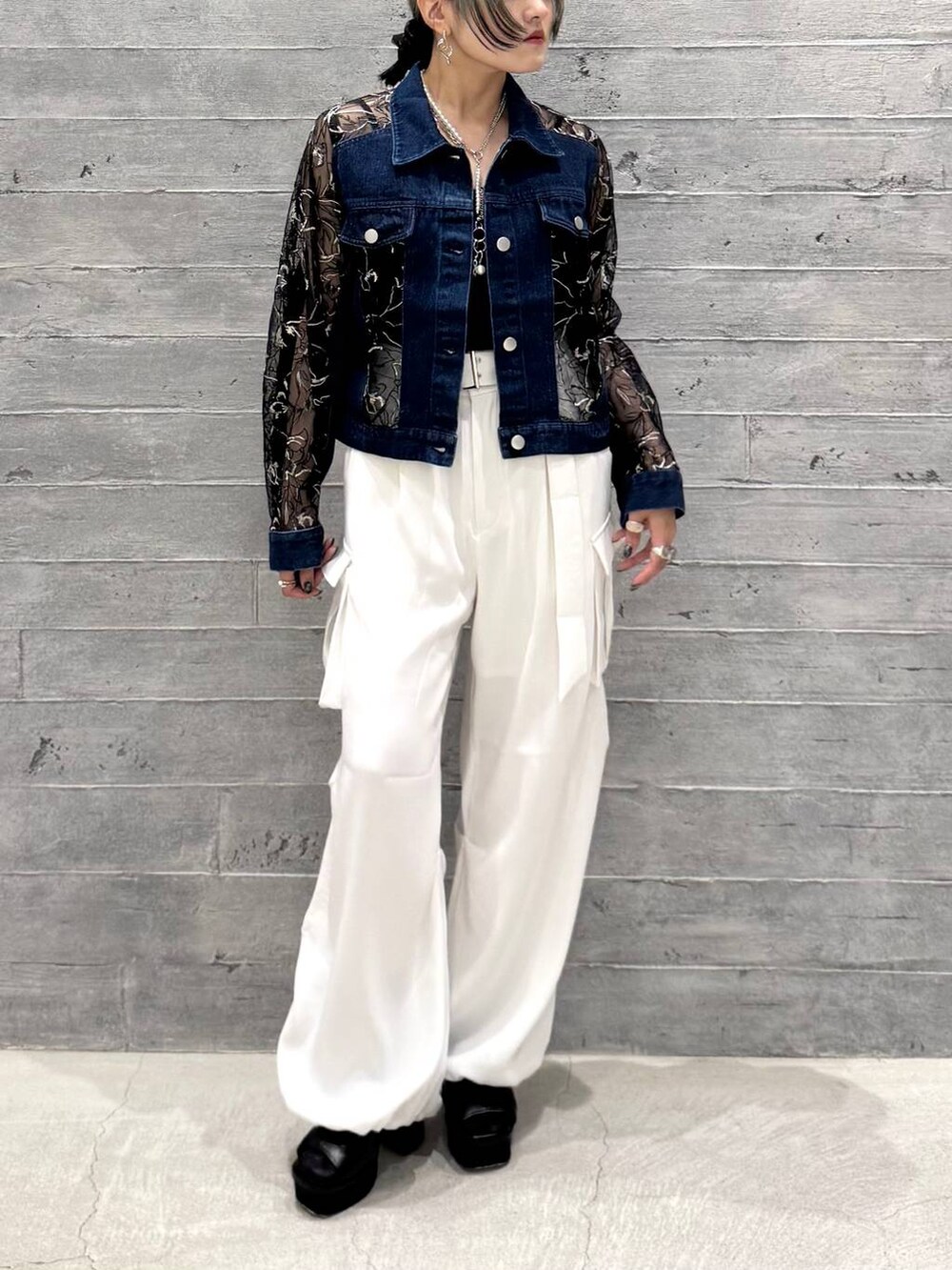 ホワイト系のカーゴパンツ、ブラック系のサンダル、ブルー系のデニムジャケットを着用したレディースの夏コーディネートの3枚目の写真