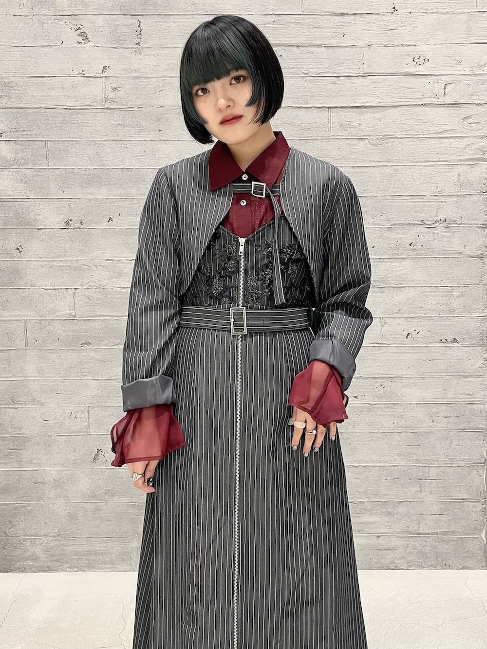 ブラック系のパンプス、その他のジャンパースカート、レッド系のシャツ/ブラウスを着用したレディースの夏コーディネートの2枚目の写真