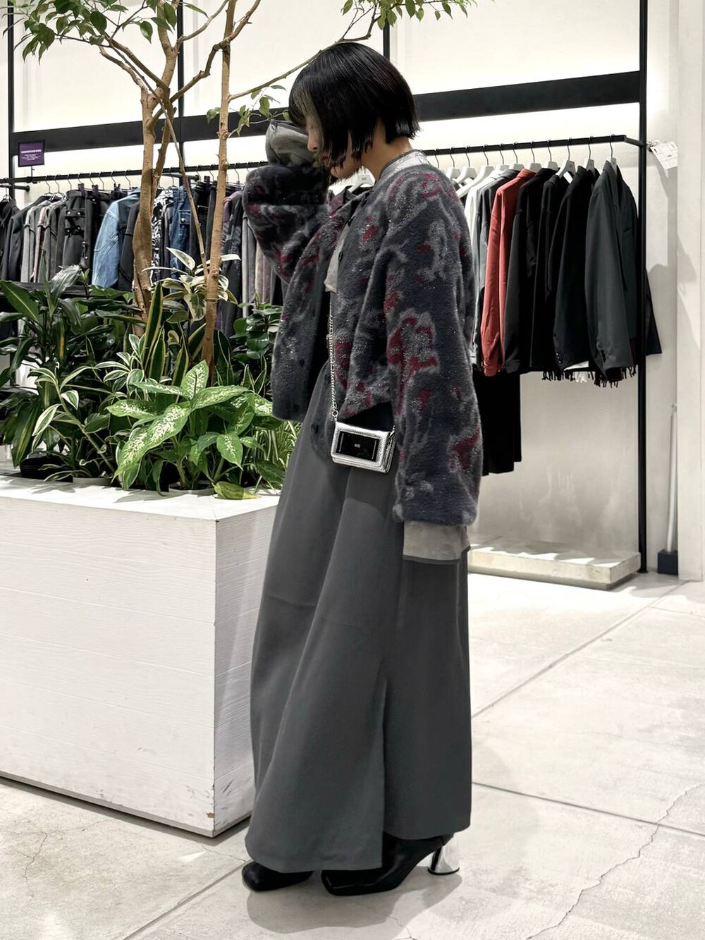 ブラック系のブーツ、ブラック系のカーディガン/ボレロ、グレー系のワンピースを着用したレディースの秋コーディネートの3枚目の写真