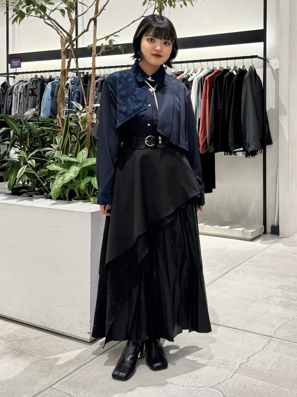 ブラック系のスカート、ブラック系のブーツ、ブルー系のシャツ/ブラウスを着用したレディースの秋コーディネートの4枚目の写真