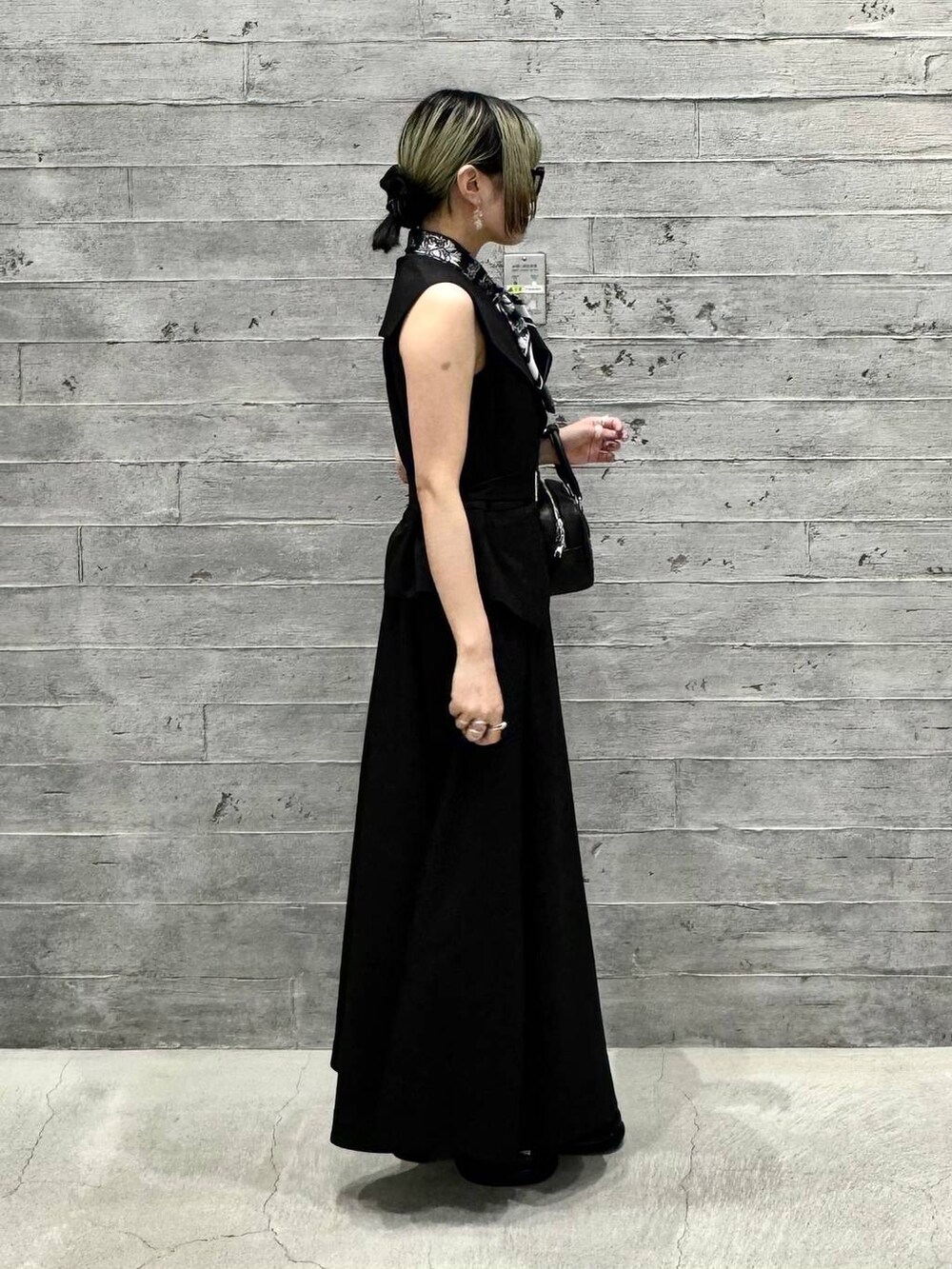 ブラック系のワンピース、ブラック系のローファー、ブラック系のボストンバッグを着用したレディースの夏コーディネートの6枚目の写真