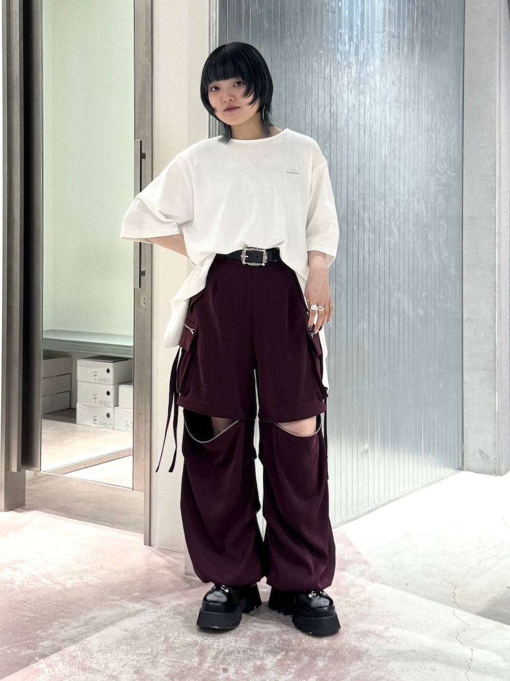 ブラック系のテーラードジャケット、レッド系のその他パンツ、シルバー系のタンクトップを着用したレディースの夏コーディネートの3枚目の写真