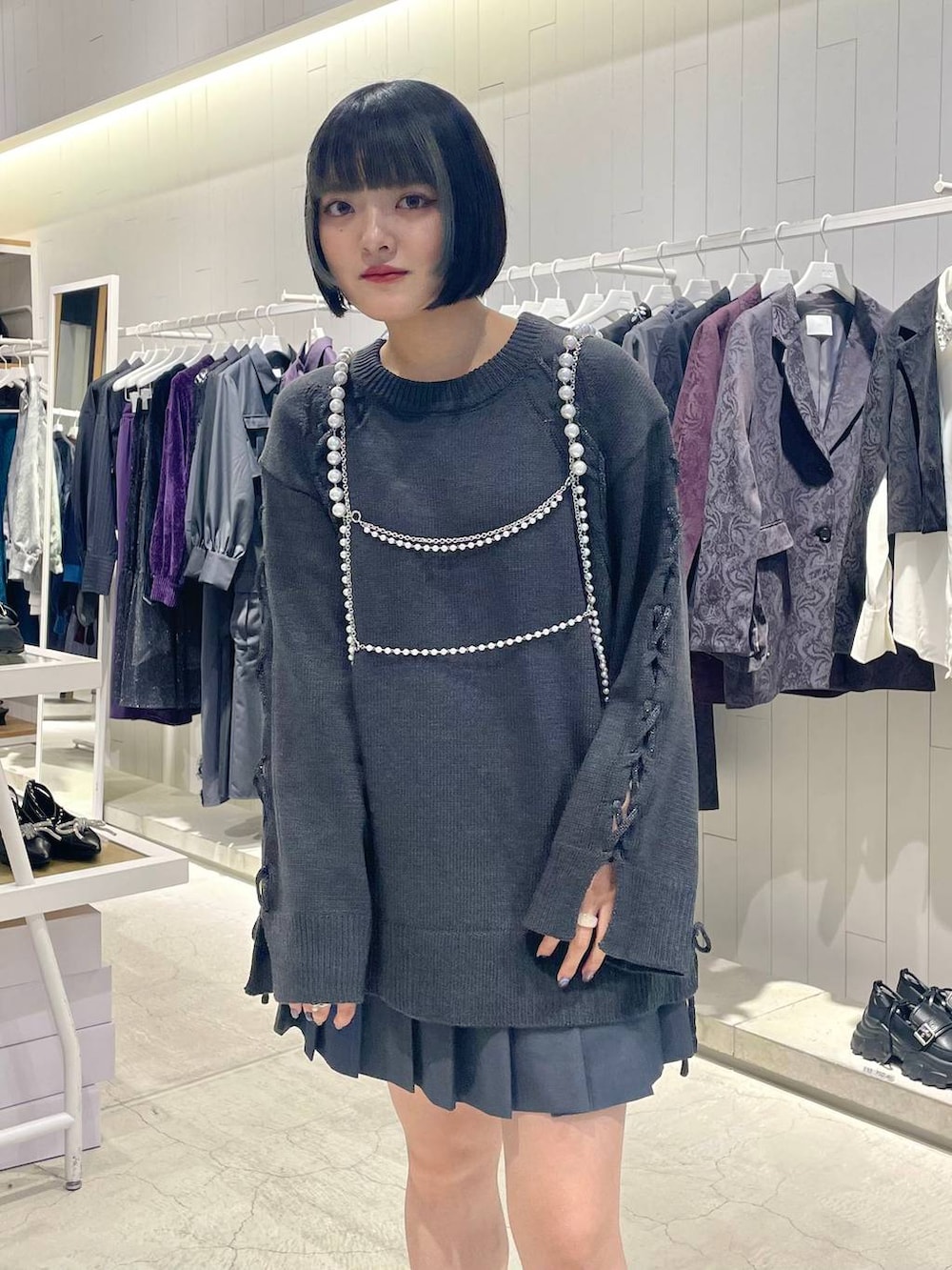 グレー系のテーラードジャケット、ブラック系のブーツ、グレー系のニット/セーターを着用したレディースの秋コーディネートの2枚目の写真