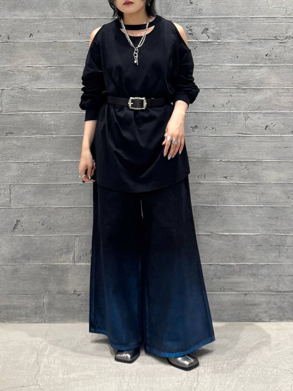 ブラック系のTシャツ/カットソー、シルバー系のブーツ、ブラック系のデニムパンツを着用したレディースの夏コーディネートの3枚目の写真