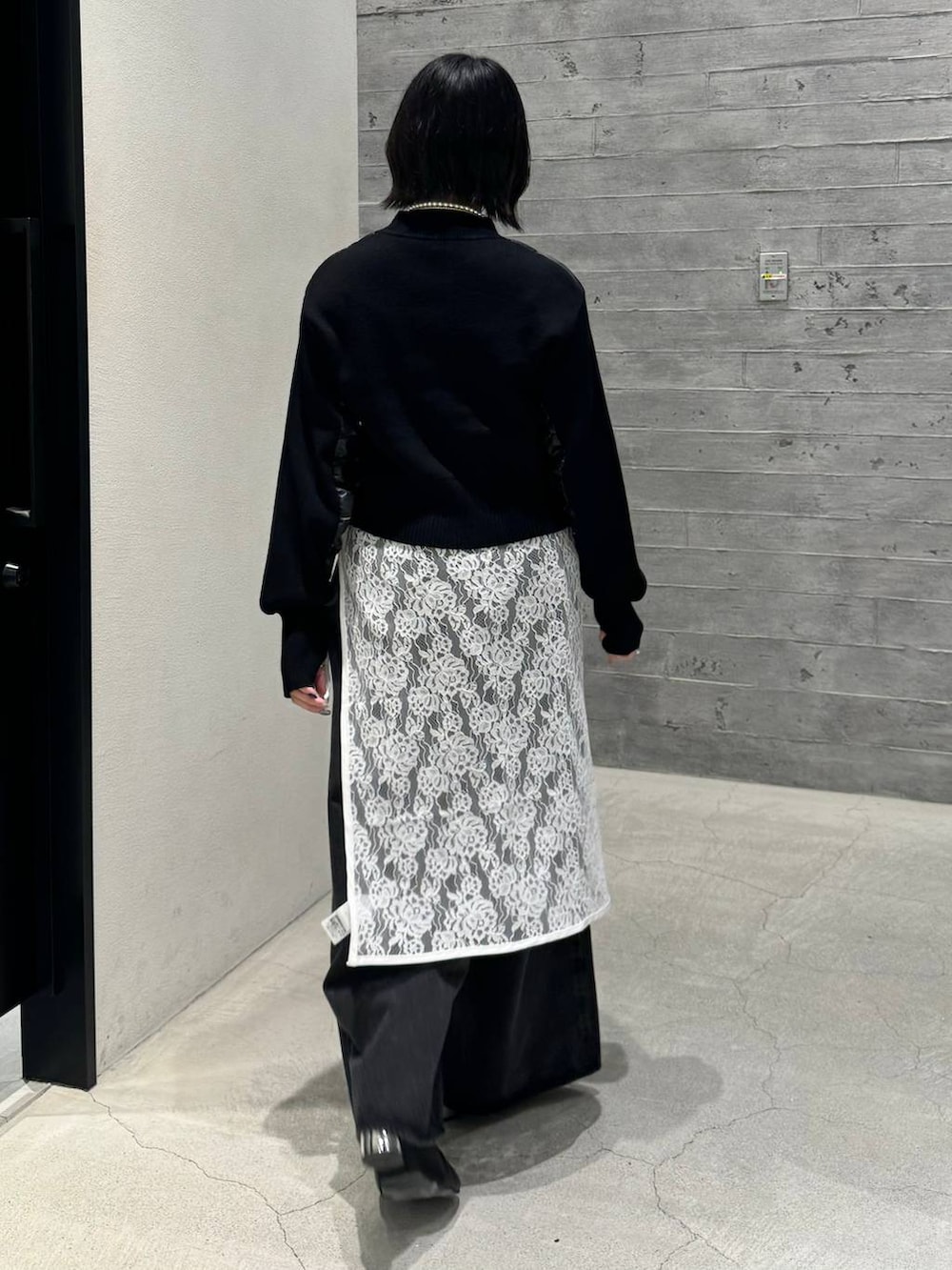 ブラック系のブーツ、ブラック系のデニムパンツ、ブラック系のニット/セーターを着用したレディースの秋コーディネートの4枚目の写真