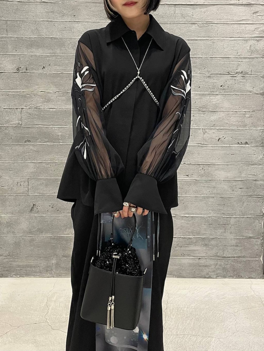 ブラック系のサンダル、ブラック系のショルダーバッグ、ブラック系のシャツ/ブラウスを着用したレディースの夏コーディネートの2枚目の写真