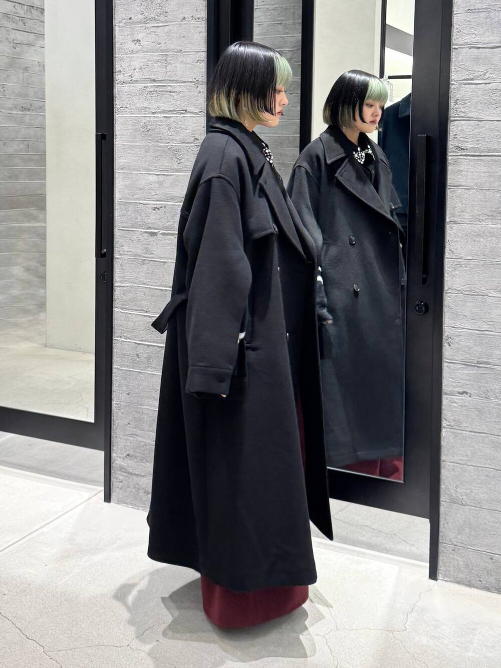 ブラック系のトレンチコート、ブラック系のシャツ/ブラウス、ブラック系のカーディガン/ボレロを着用したレディースの冬コーディネートの4枚目の写真