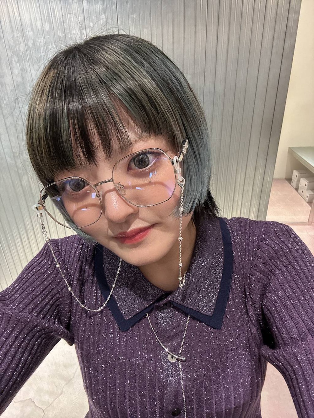 パープル系のカーディガン/ボレロ、シルバー系のメガネ、シルバー系のネックレスを着用したレディースの春コーディネートの3枚目の写真