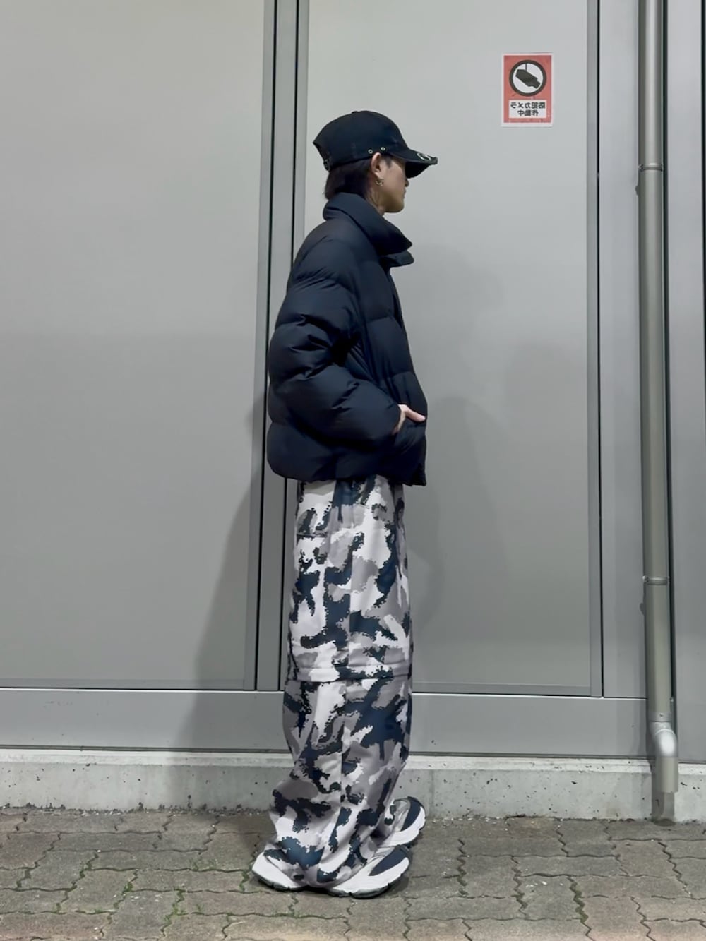 グレー系のその他パンツ、ブラック系のダウンジャケット/コート、ブラック系のスニーカーを着用したメンズの冬コーディネートの2枚目の写真