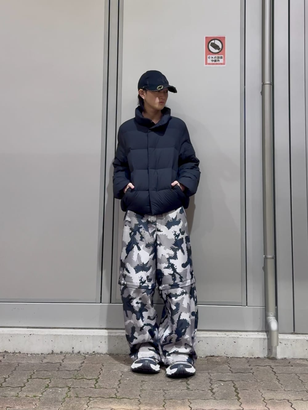 グレー系のその他パンツ、ブラック系のダウンジャケット/コート、ブラック系のスニーカーを着用したメンズの冬コーディネートの3枚目の写真