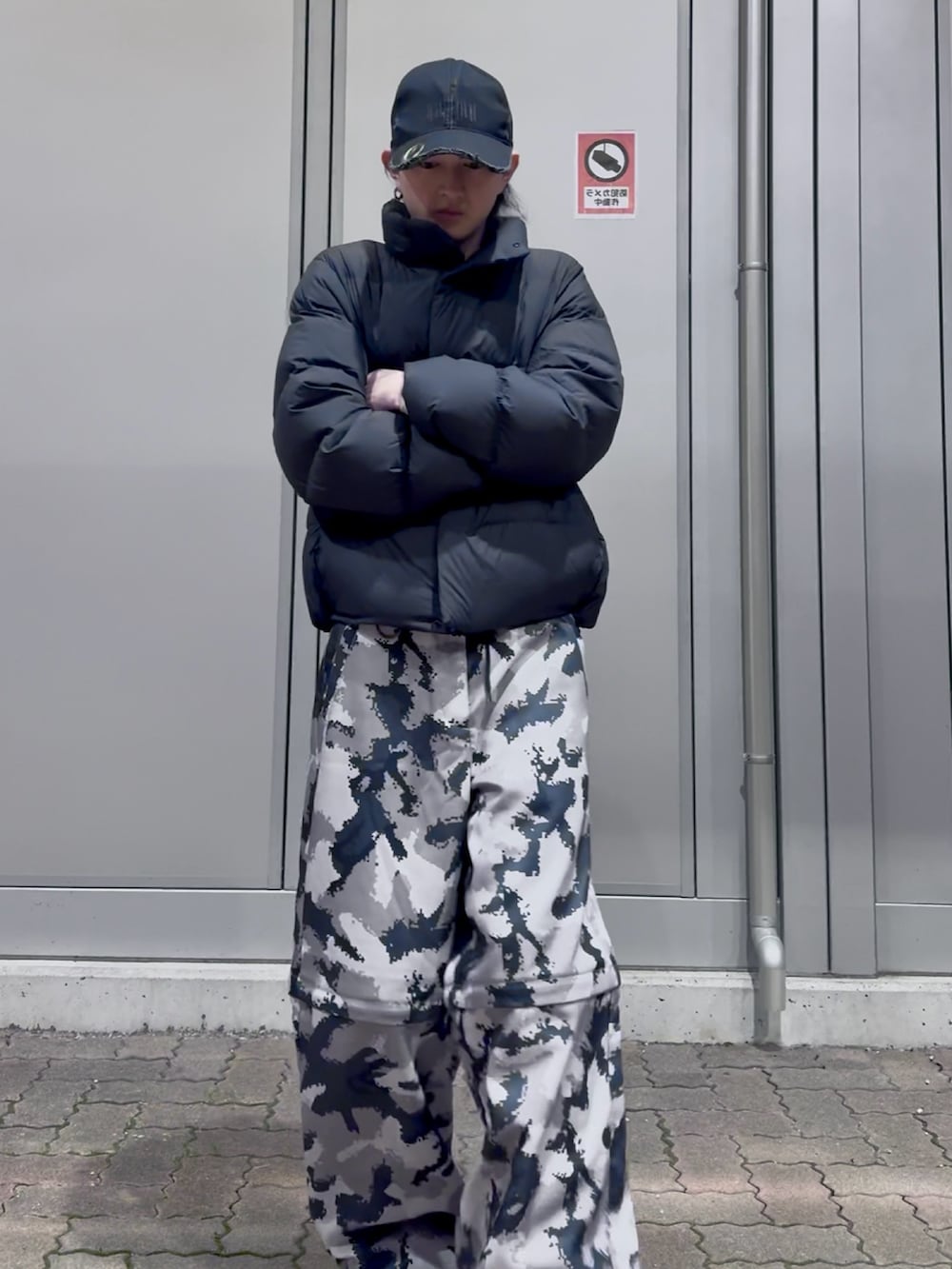 グレー系のその他パンツ、ブラック系のダウンジャケット/コート、ブラック系のスニーカーを着用したメンズの冬コーディネートの5枚目の写真