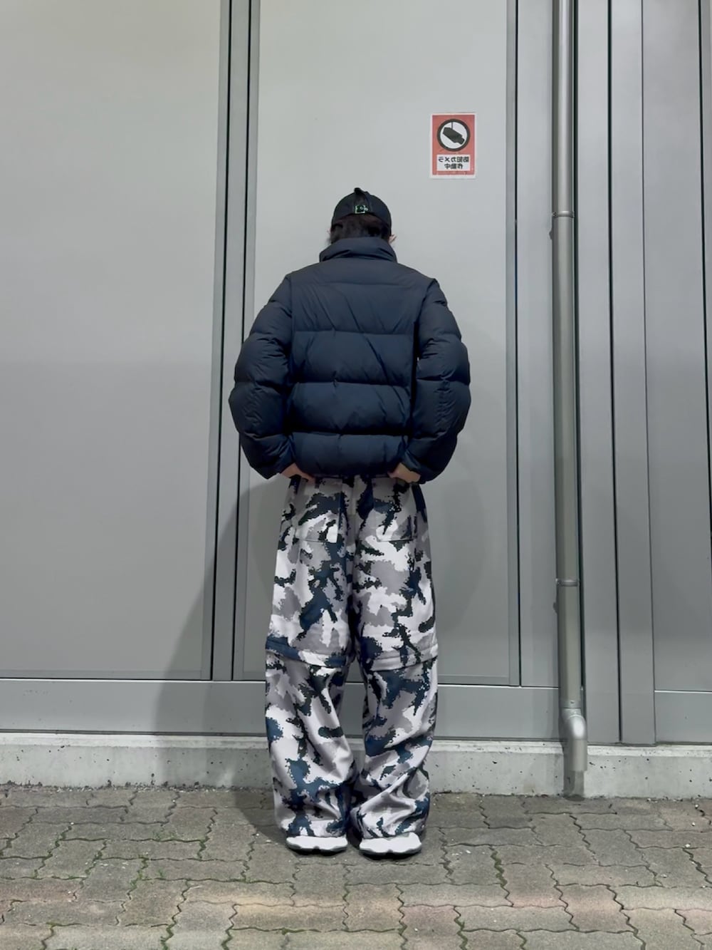 グレー系のその他パンツ、ブラック系のダウンジャケット/コート、ブラック系のスニーカーを着用したメンズの冬コーディネートの4枚目の写真