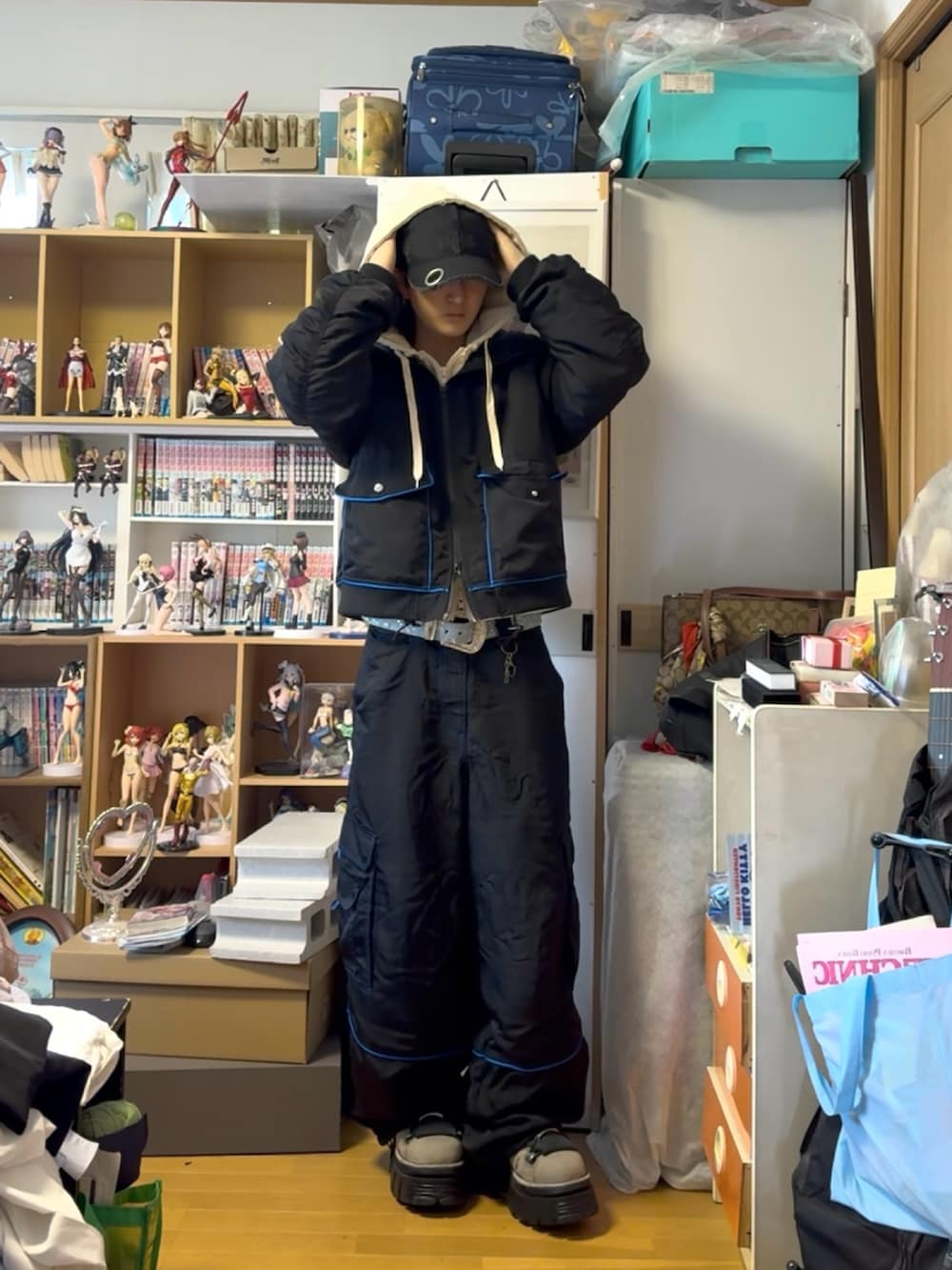 ブラック系のカーゴパンツ、ホワイト系のパーカー、ブラック系のブルゾンを着用したメンズの春コーディネートの3枚目の写真