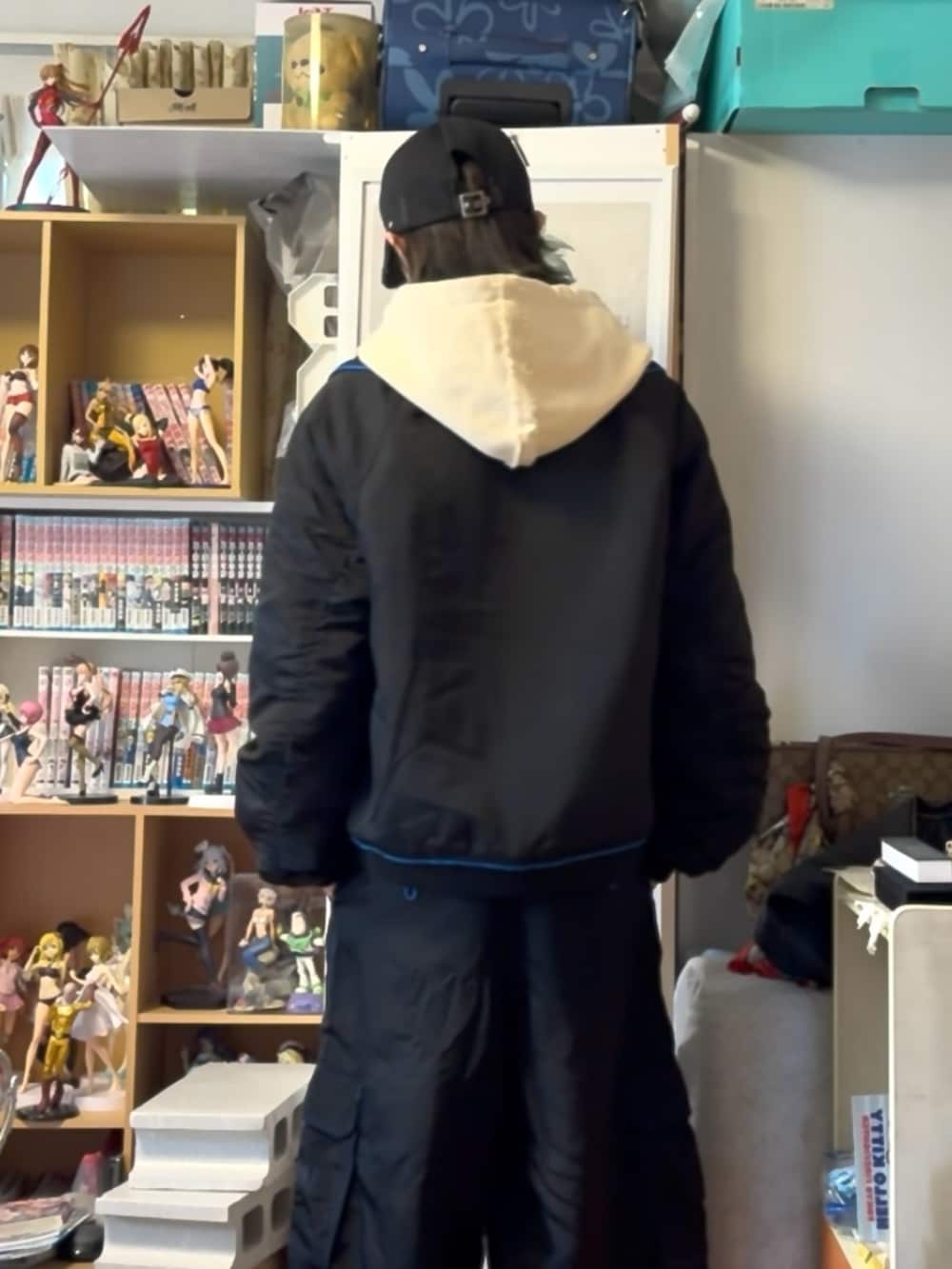 ブラック系のカーゴパンツ、ホワイト系のパーカー、ブラック系のブルゾンを着用したメンズの春コーディネートの4枚目の写真