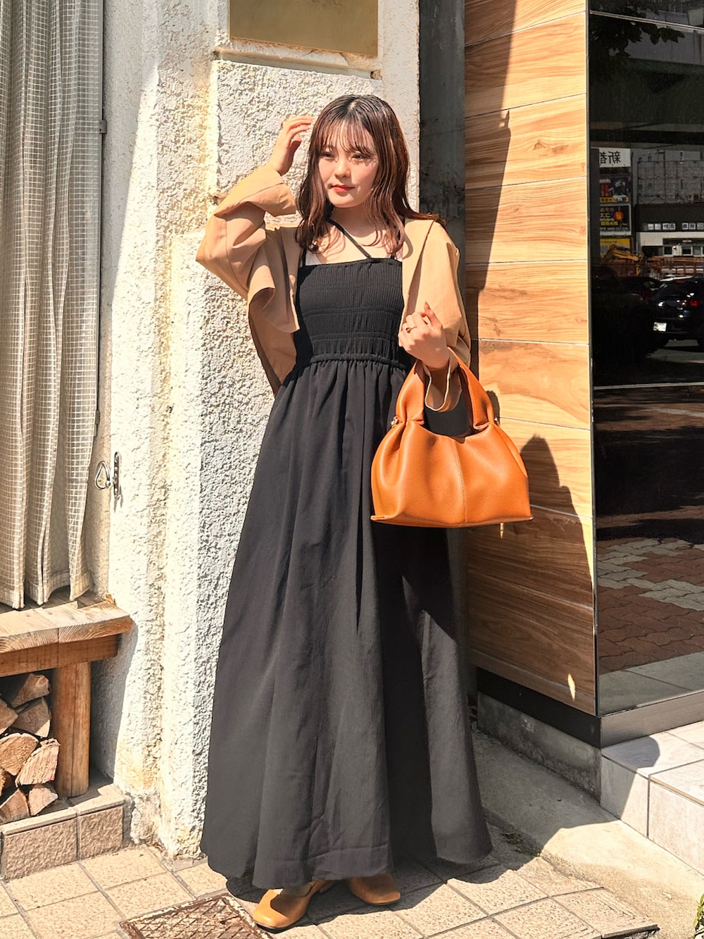 ブラック系のワンピース、オレンジ系のテーラードジャケットを着用したレディースの夏コーディネートの2枚目の写真
