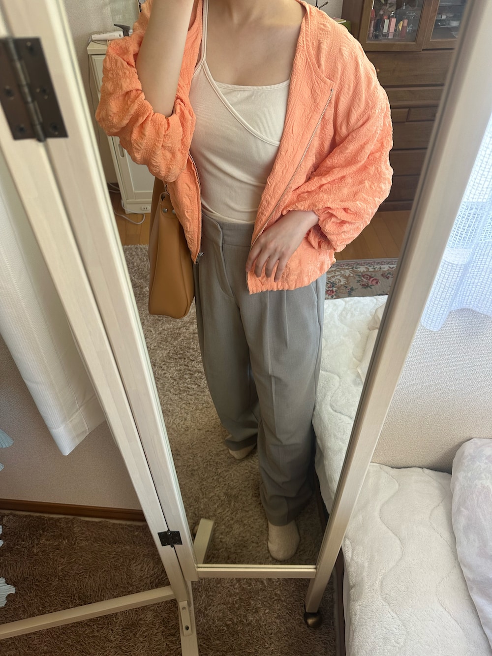 ホワイト系のキャミソール、グレー系のスラックス、ブラウン系のトートバッグを着用したレディースの夏コーディネートの4枚目の写真