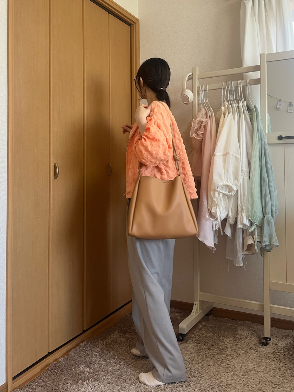 ホワイト系のキャミソール、グレー系のスラックス、ブラウン系のトートバッグを着用したレディースの夏コーディネートの3枚目の写真