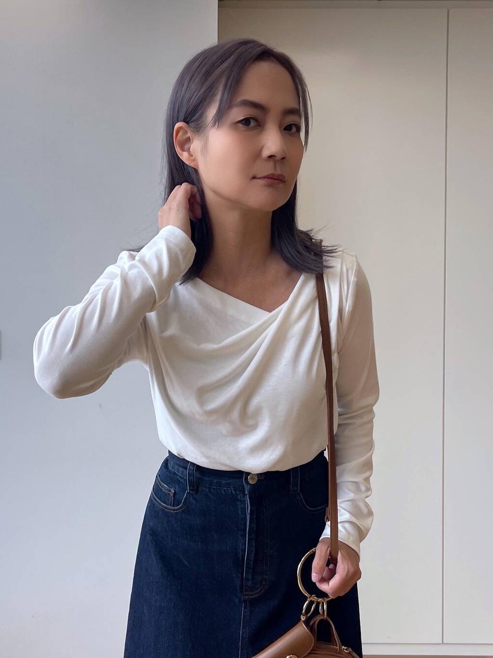 ホワイト系のサンダル、ホワイト系のTシャツ/カットソー、ブラウン系のショルダーバッグを着用したレディースの夏コーディネートの2枚目の写真
