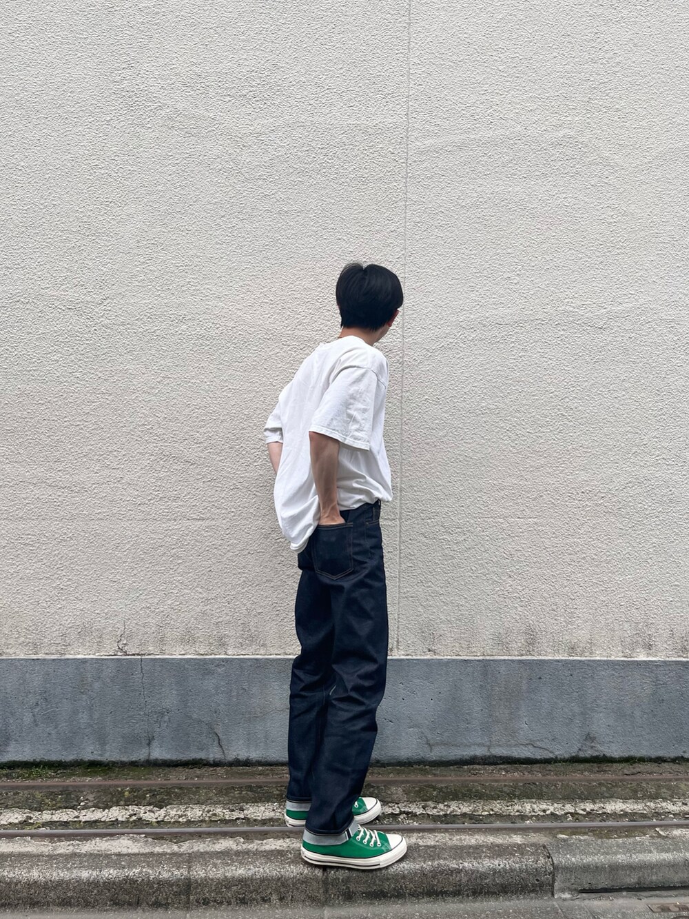ブルー系のデニムパンツ、グリーン系のスニーカーを着用したメンズの夏コーディネートの2枚目の写真
