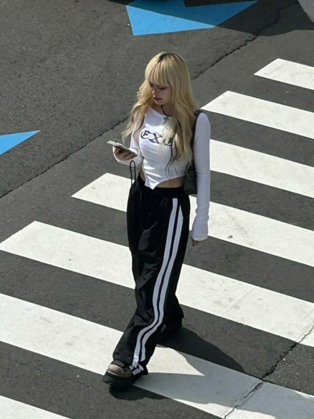 ホワイト系のTシャツ/カットソー、ブラック系のショルダーバッグ、ブラック系のカーゴパンツを着用したレディースの秋コーディネートの2枚目の写真