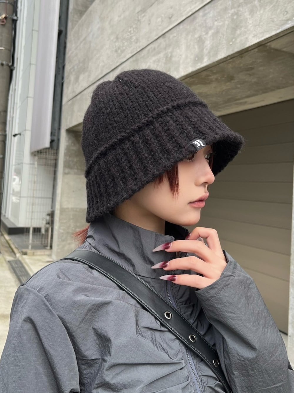 ホワイト系のスニーカー、ブラック系のハットを着用したレディースの冬コーディネートの2枚目の写真