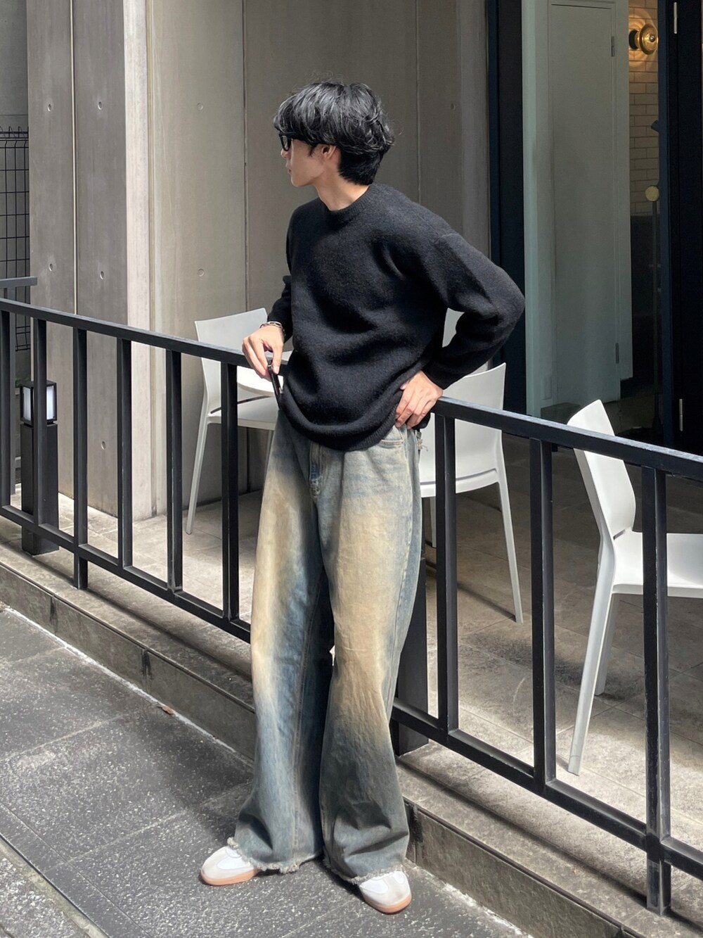 ブラック系のニット/セーター、ブルー系のデニムパンツを着用したメンズの秋コーディネートの2枚目の写真