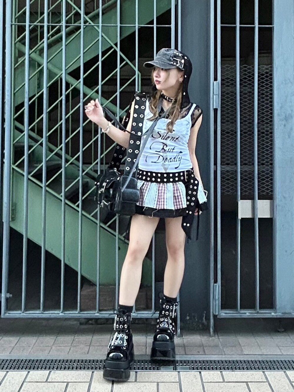 ホワイト系のキャミソール、ブラック系のスカート、ブラック系のショルダーバッグを着用したレディースの夏コーディネートの2枚目の写真