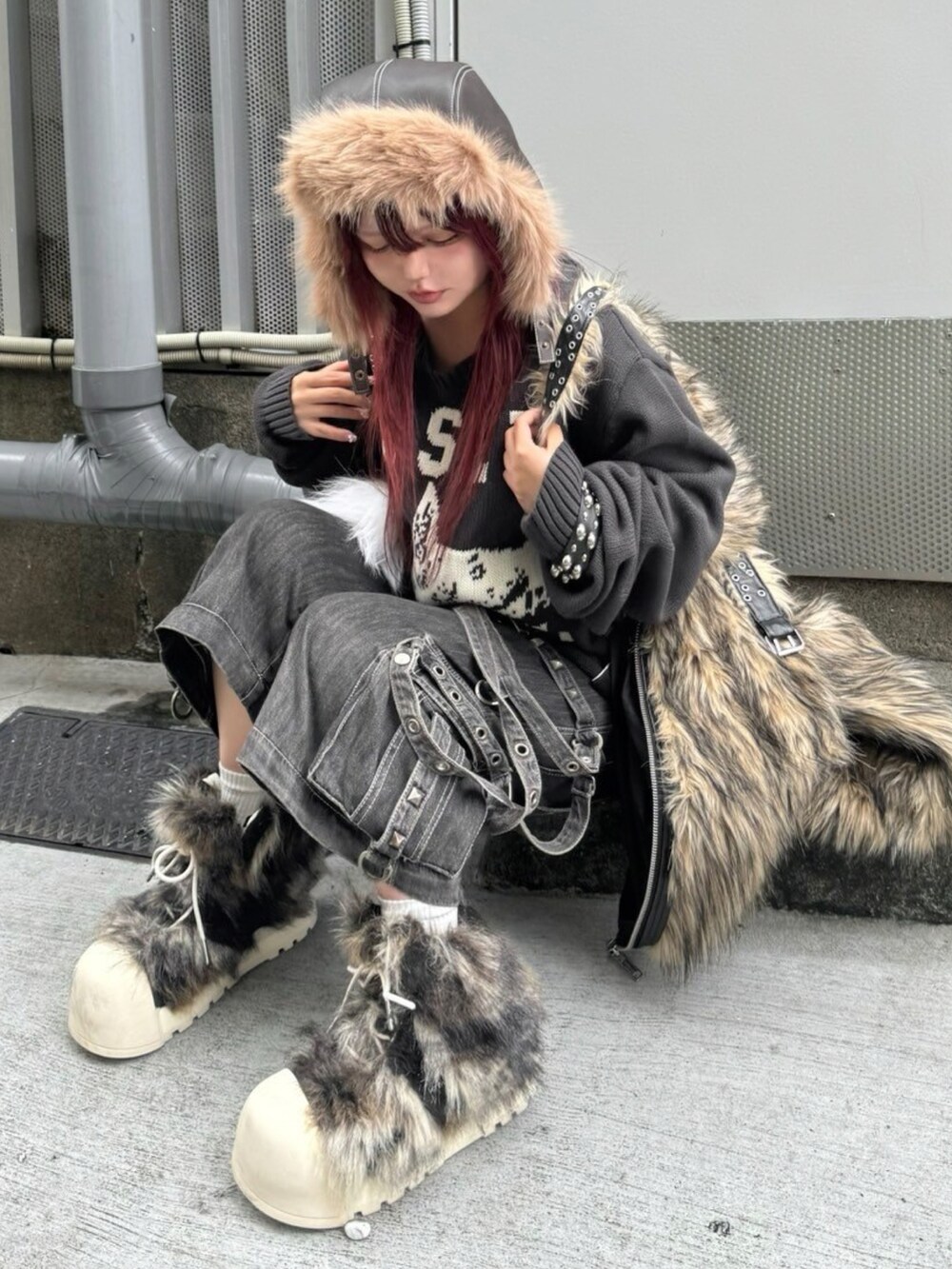 ブラック系のニット/セーター、ブラック系のブーツを着用したレディースの秋コーディネートの5枚目の写真