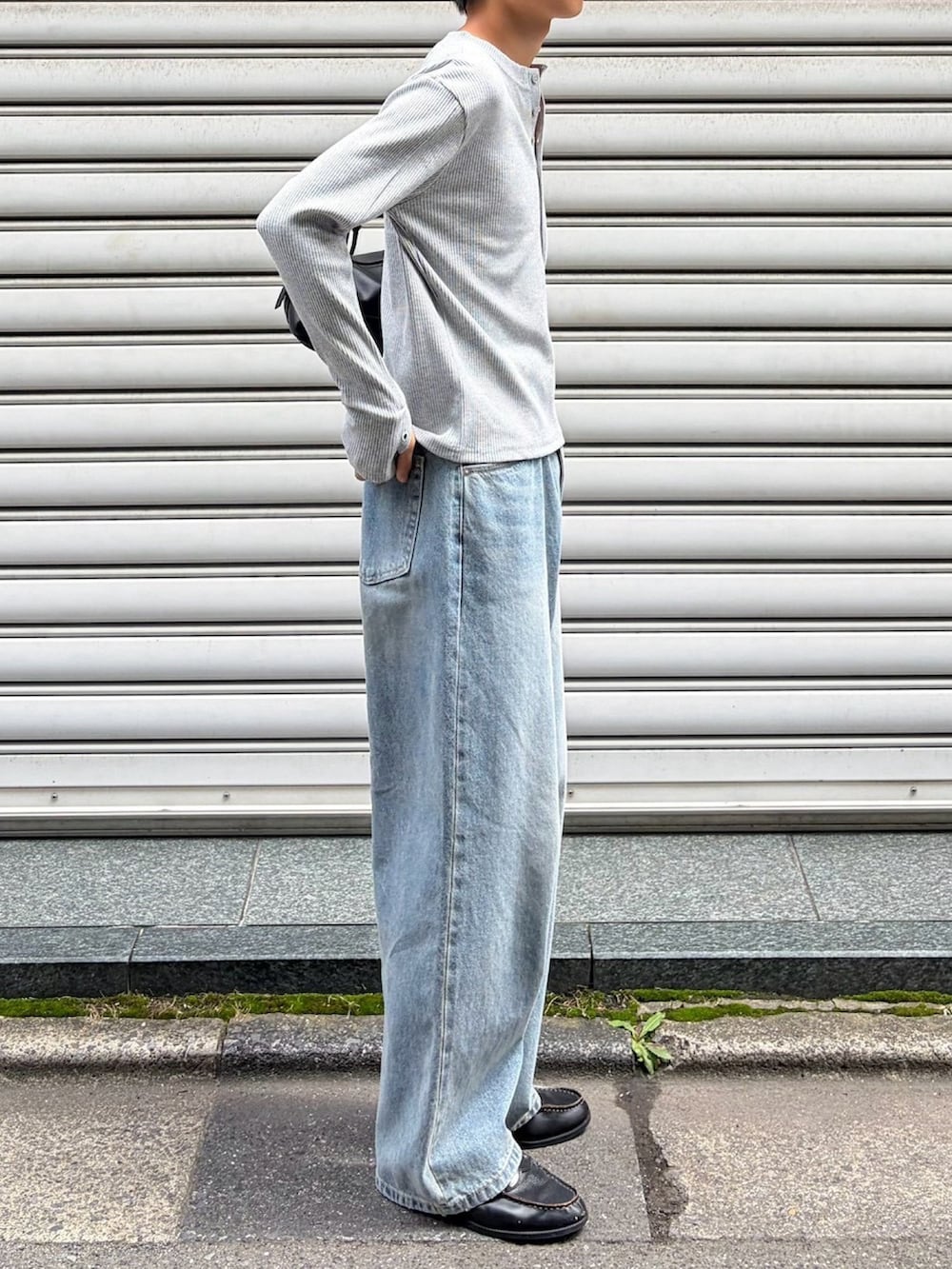 グレー系のTシャツ/カットソー、ブラック系のショルダーバッグ、ブルー系のデニムパンツを着用したメンズの秋コーディネートの2枚目の写真