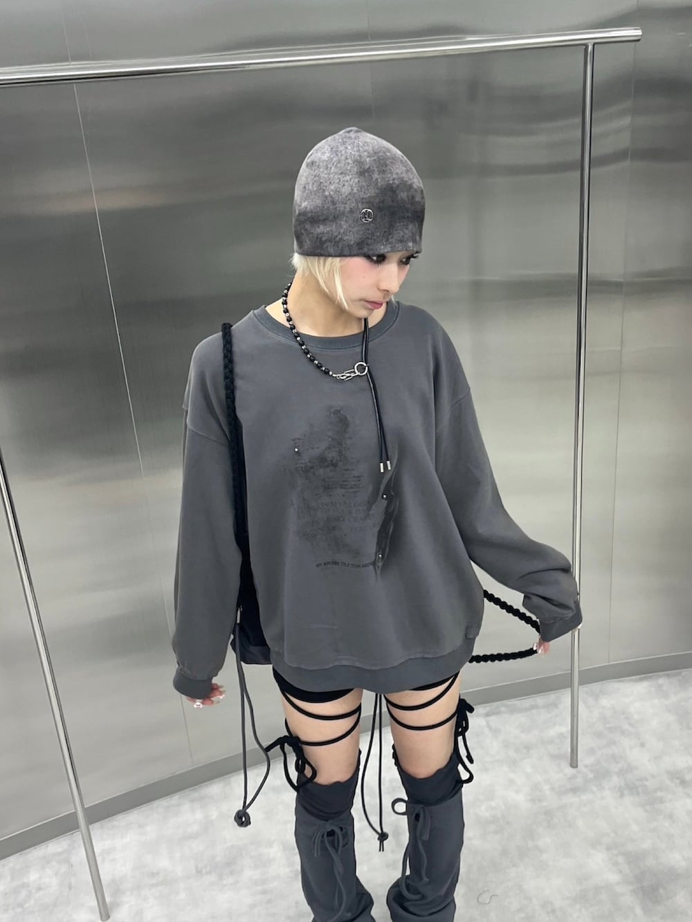 グレー系のスウェット、ブラック系のバックパック/リュック、パープル系のニットキャップ/ビーニーを着用したレディースの秋コーディネートの3枚目の写真