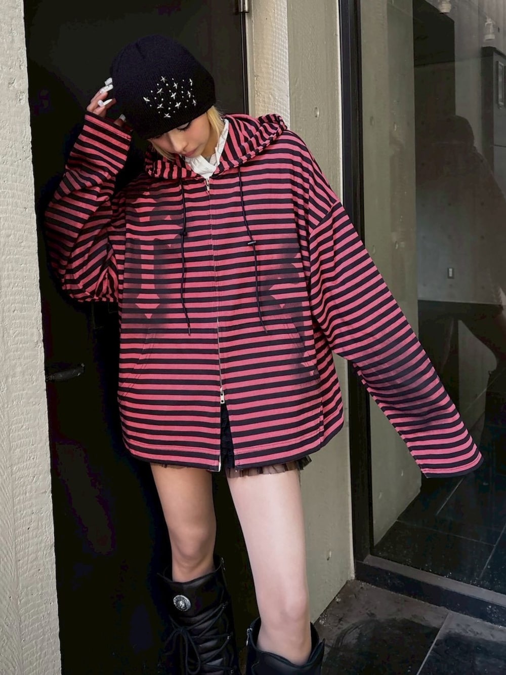 レッド系のパーカー、ブラック系のニットキャップ/ビーニーを着用したレディースの春コーディネートの4枚目の写真