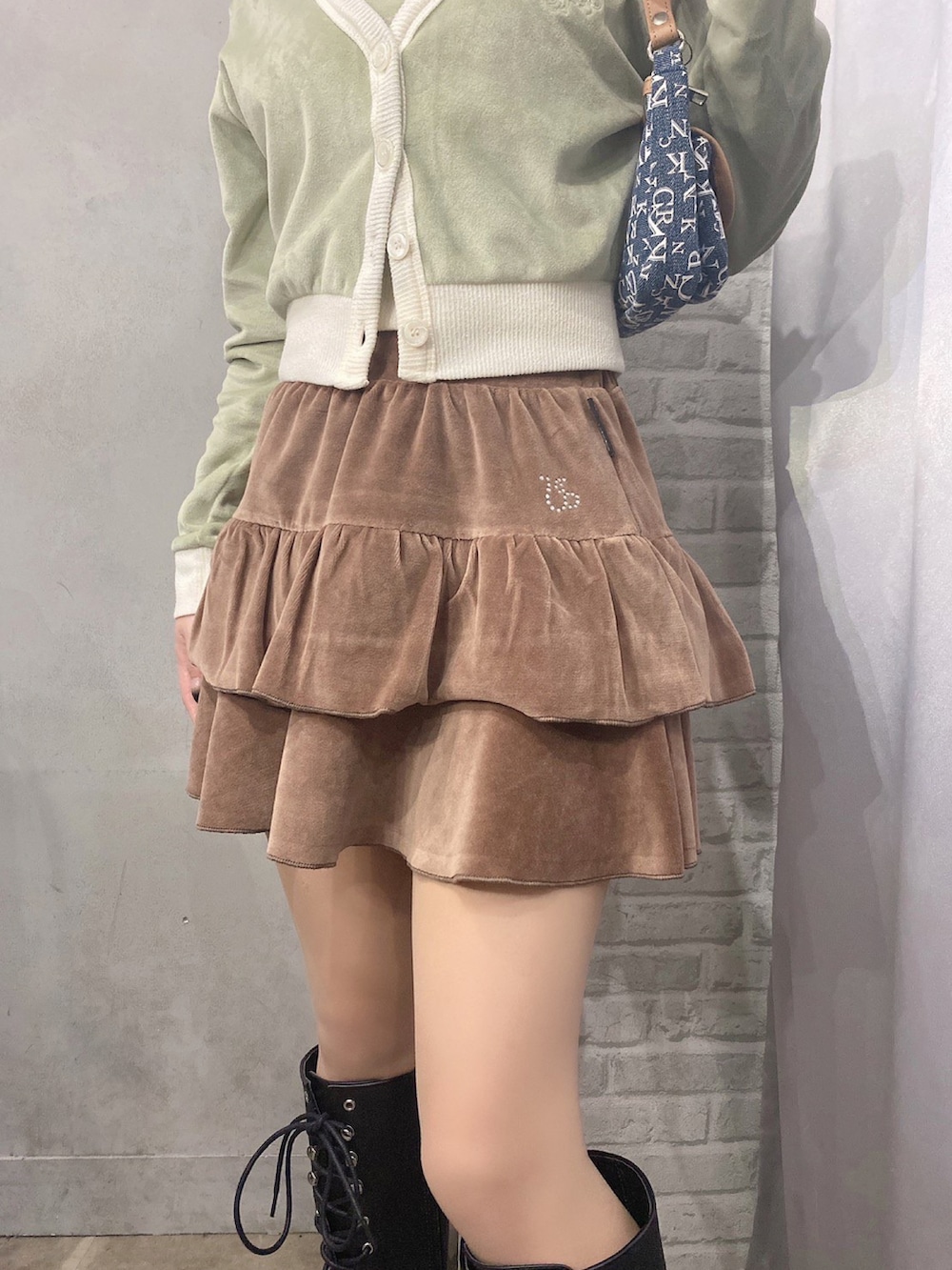 グリーン系のカーディガン/ボレロ、ブラウン系のスカート、ブラウン系のニットキャップ/ビーニーを着用したレディースの冬コーディネートの2枚目の写真
