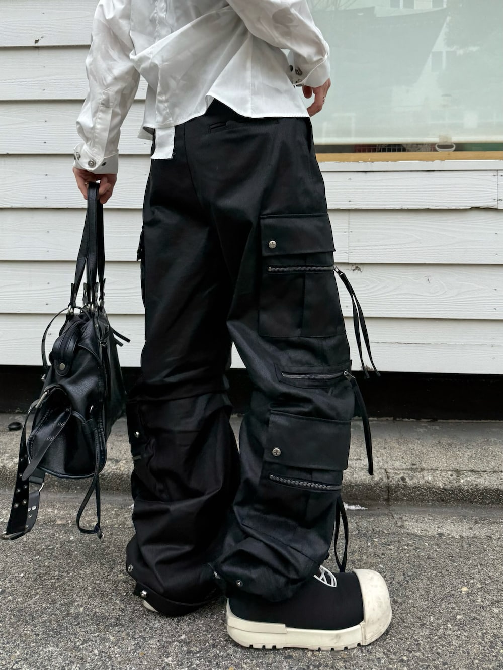 ブラック系のカーゴパンツ、ホワイト系のニットキャップ/ビーニーを着用したメンズの夏コーディネートの5枚目の写真