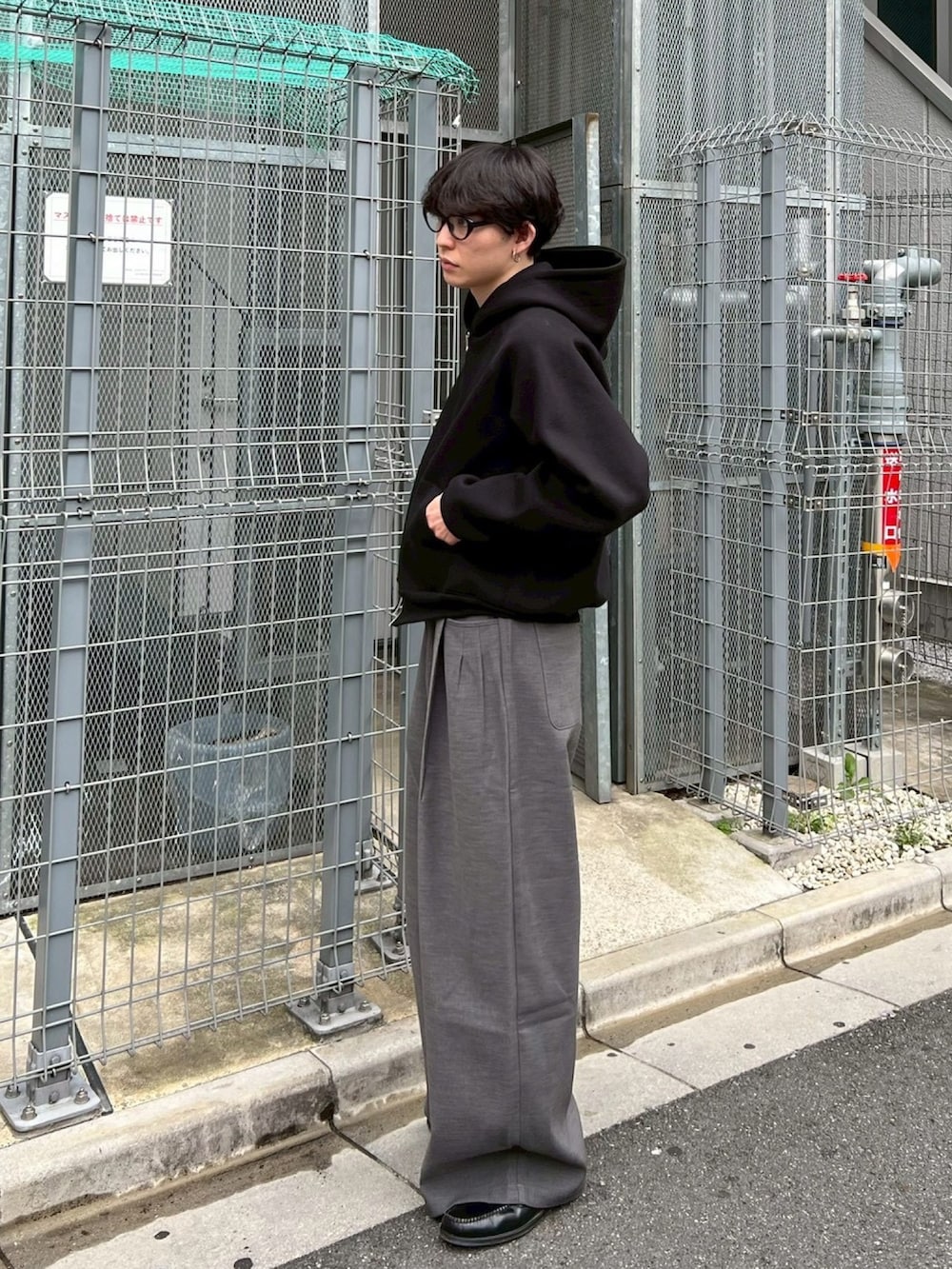 ブラック系のパーカー、グレー系のスラックスを着用したメンズの冬コーディネートの3枚目の写真