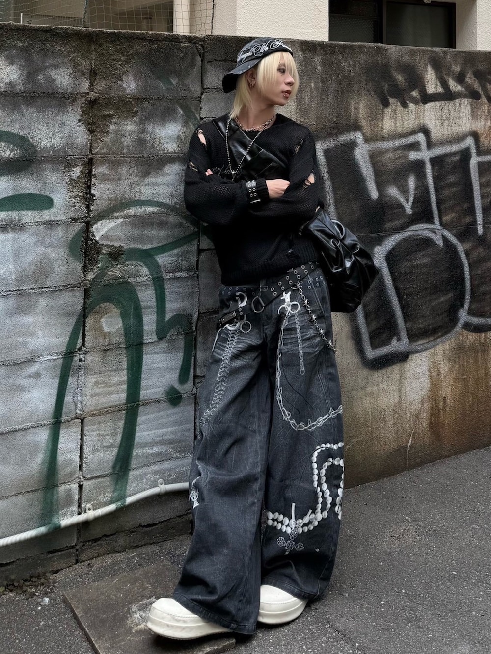 ブラック系のニット/セーター、ブラック系のデニムパンツ、シルバー系のネックレスを着用したメンズの冬コーディネートの2枚目の写真