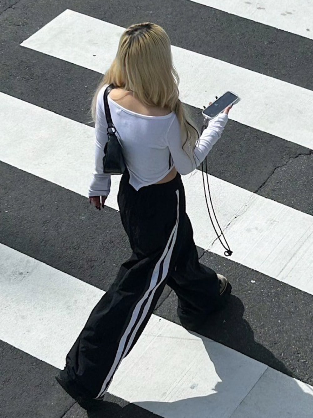 ホワイト系のTシャツ/カットソー、ブラック系のショルダーバッグ、ブラック系のカーゴパンツを着用したレディースの秋コーディネートの5枚目の写真